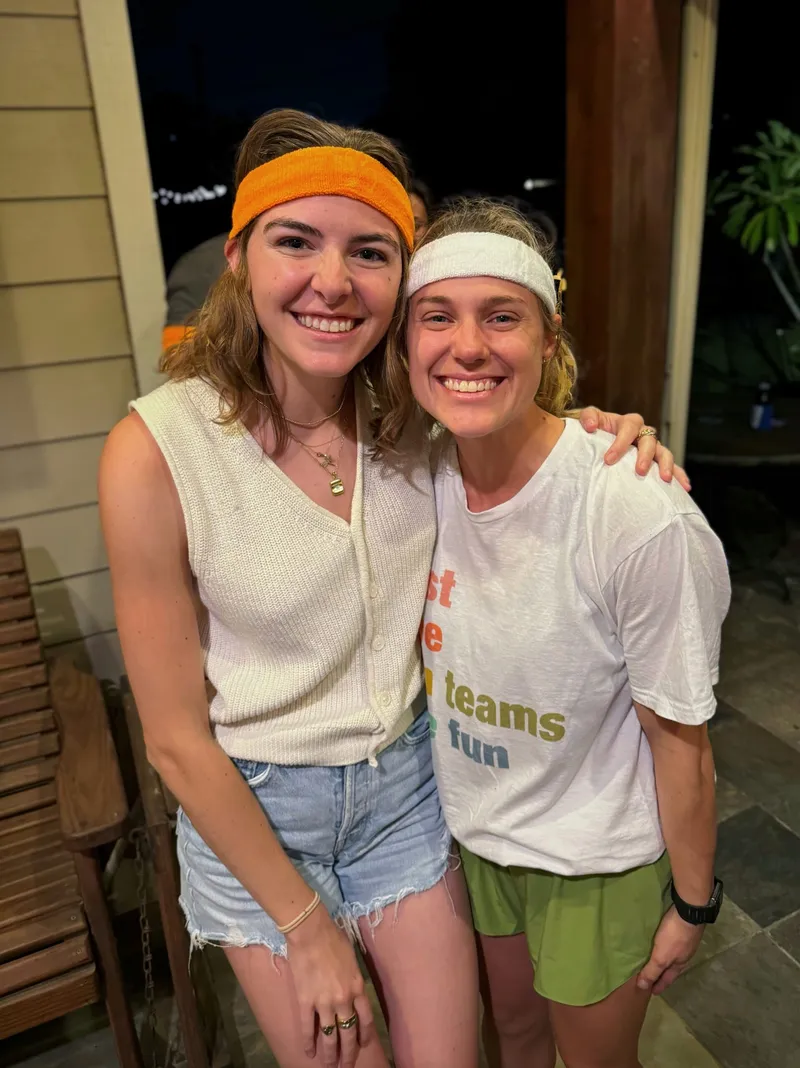 Two friends wearing colored headbands at a 30th birthday party, showing the team color icebreaker system