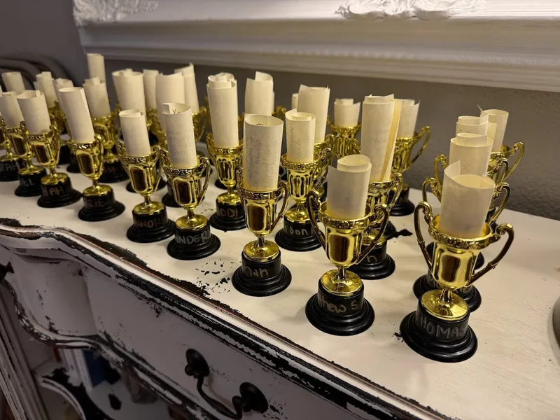 Participation trophies displayed as fun decorations at a competition-themed 30th birthday party