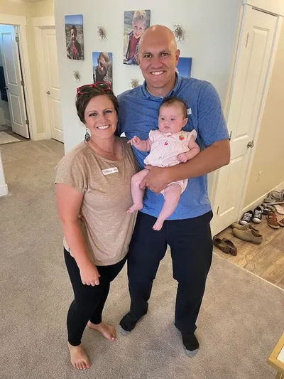 a photo of a woman, man, and a baby