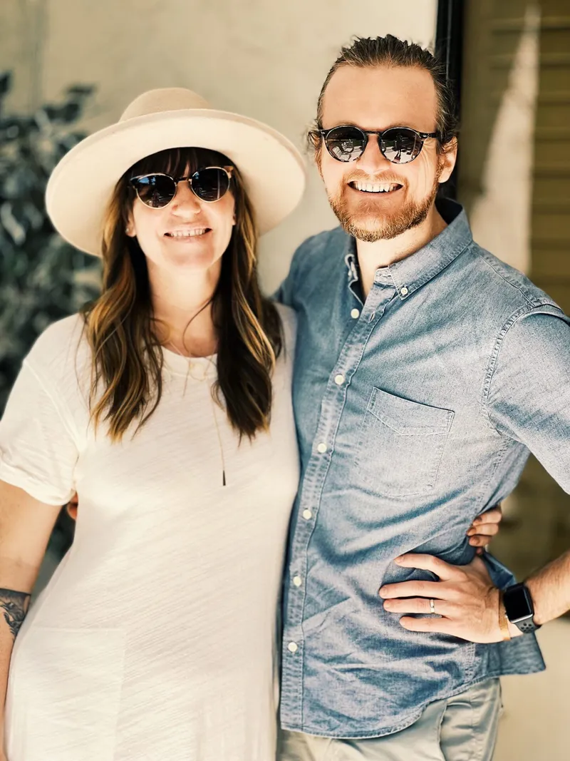 photo of a man and woman with sunglasses smiling holding each other