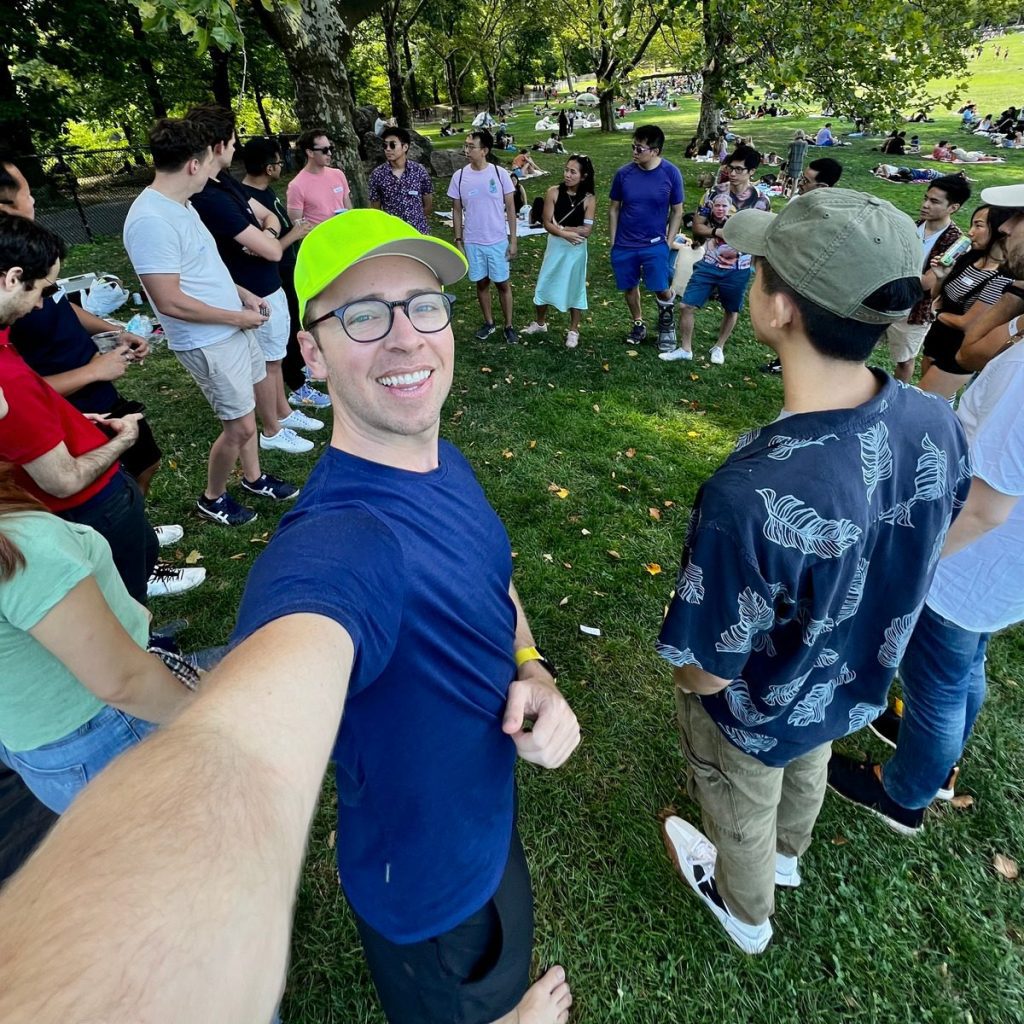 Nick taking a selfie while guests circled up for the icebreakers at the picnic party